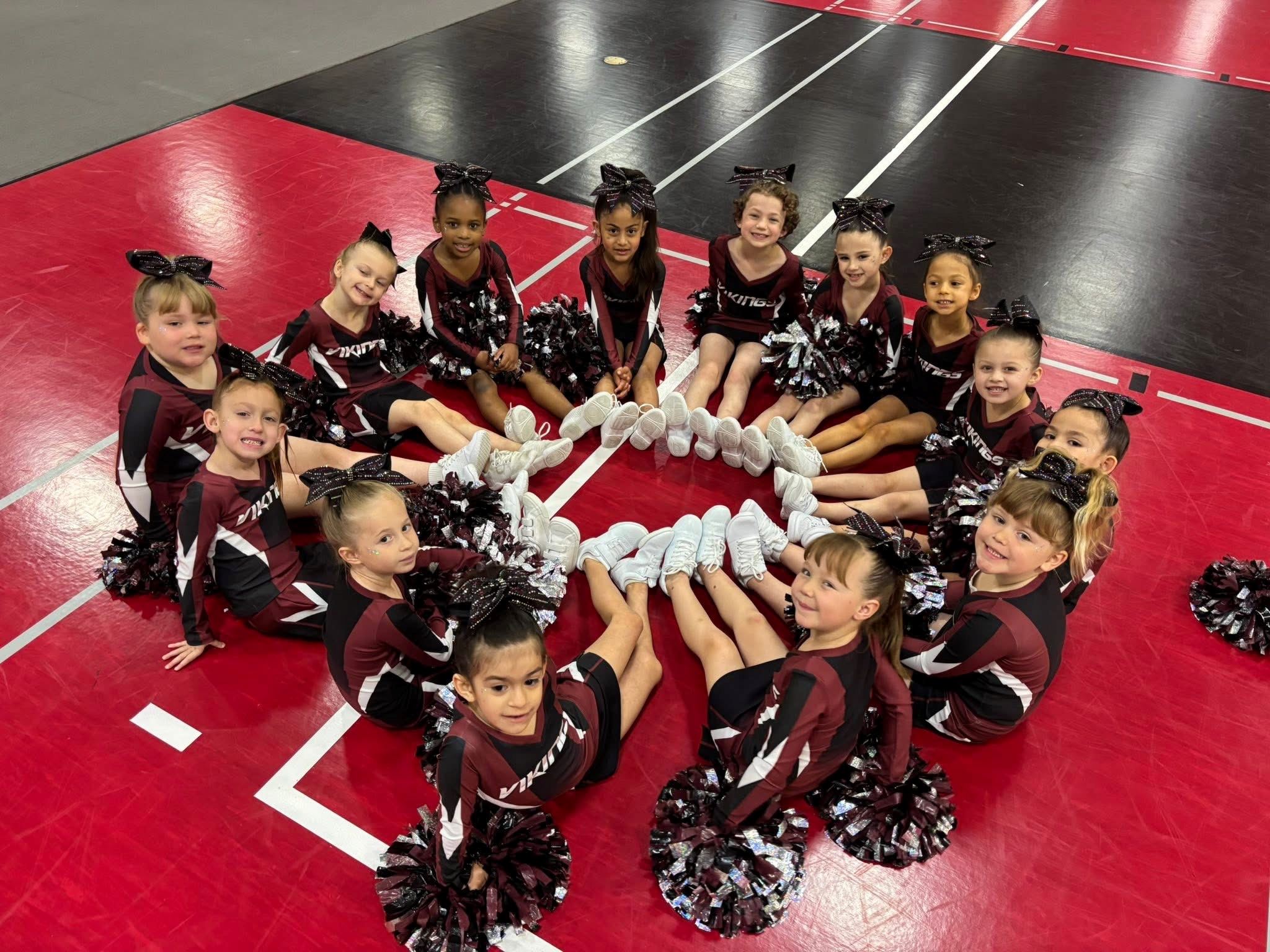 Photo of young Ignite cheerleaders in circle with shoes touching